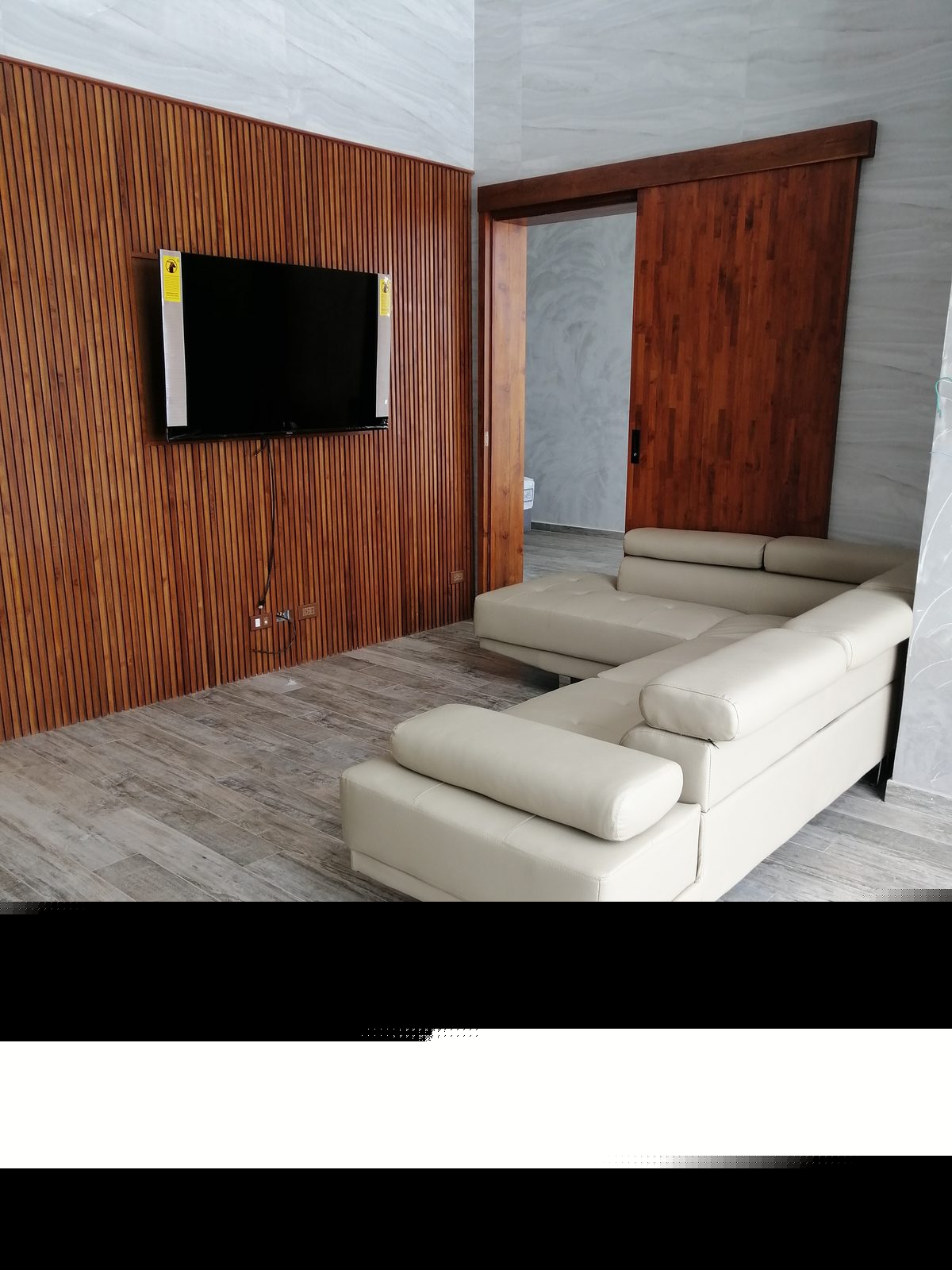 Living room — white sofa, wood wall, Smart TV
